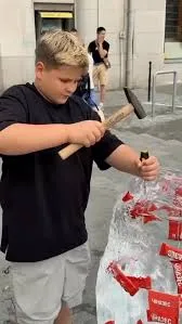 Creator using a branded ice hammer to chip Red Bull out of an ice-block PR box